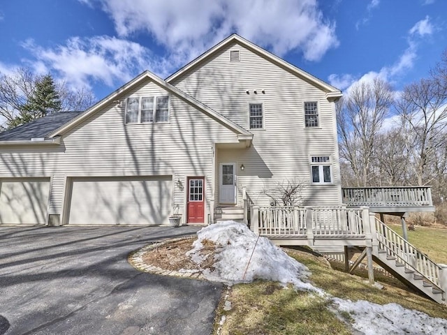 rear view of property with a deck and driveway