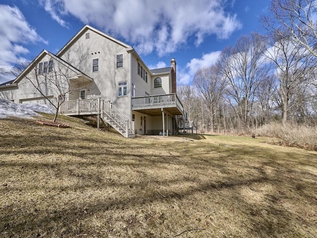 back of property featuring a yard, stairway, a chimney, and a deck