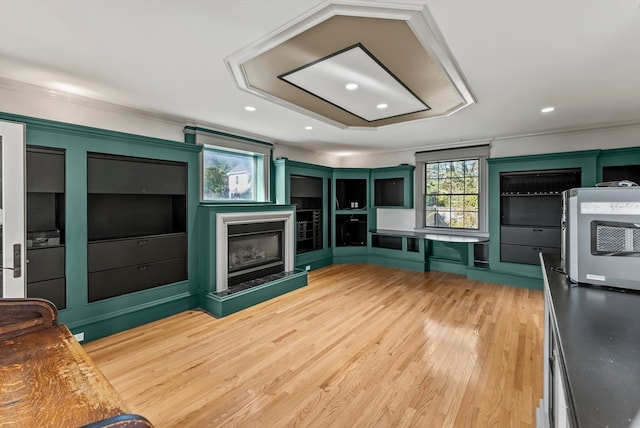 unfurnished living room with ornamental molding and hardwood / wood-style flooring