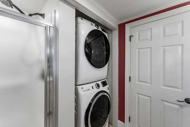 laundry area featuring stacked washing maching and dryer and crown molding