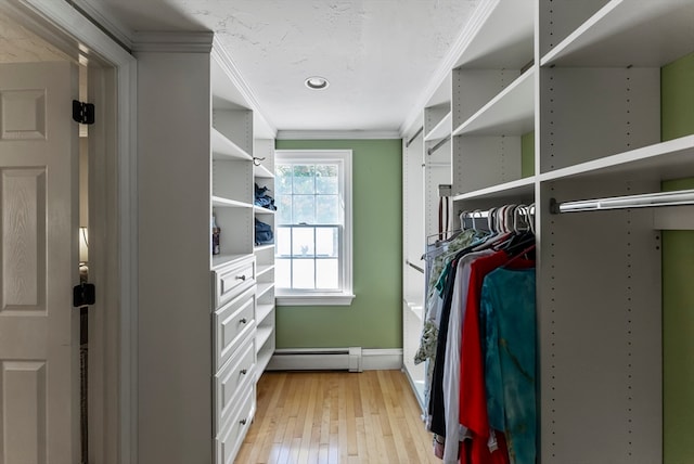 walk in closet with light hardwood / wood-style flooring and a baseboard heating unit