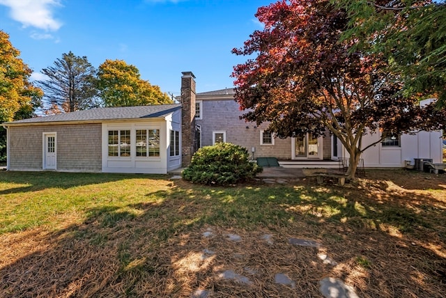 rear view of property featuring a patio area and a lawn