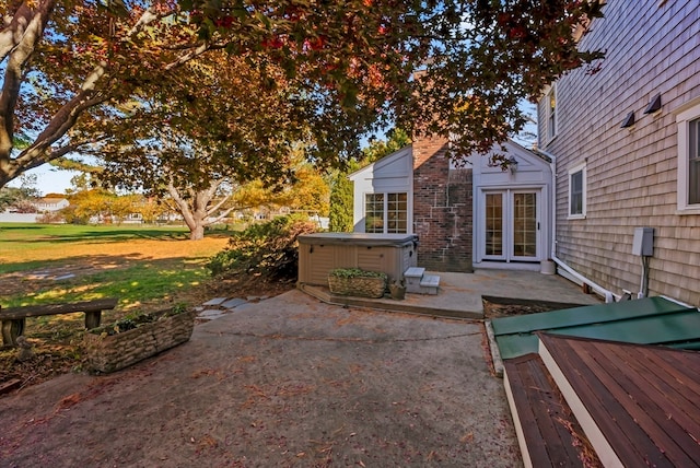 view of patio with a hot tub and french doors