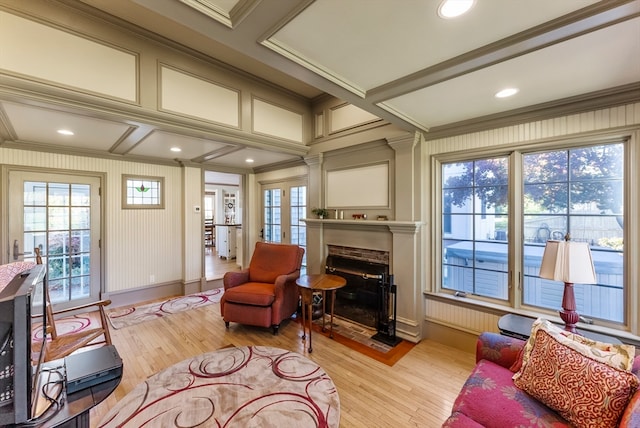 sitting room featuring crown molding, light hardwood / wood-style flooring, and coffered ceiling