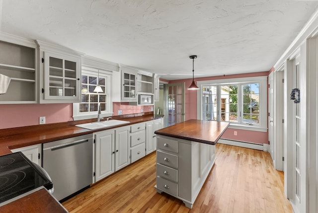 kitchen with a kitchen island, a baseboard heating unit, wood counters, sink, and appliances with stainless steel finishes