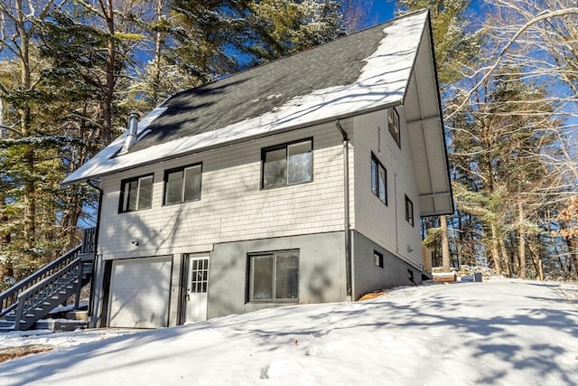 snow covered property featuring a garage