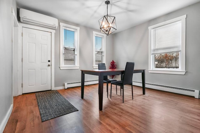 dining space with hardwood / wood-style floors, a wall unit AC, a baseboard heating unit, and a notable chandelier