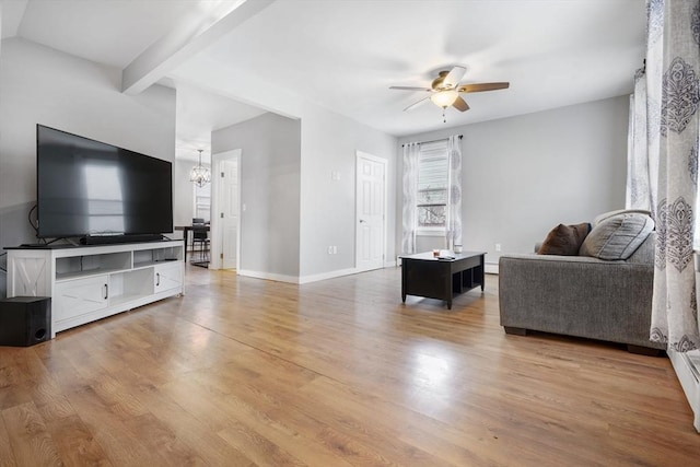 living room featuring beamed ceiling, ceiling fan with notable chandelier, and light wood-type flooring