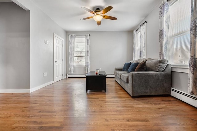 living room with hardwood / wood-style flooring, ceiling fan, and a baseboard heating unit