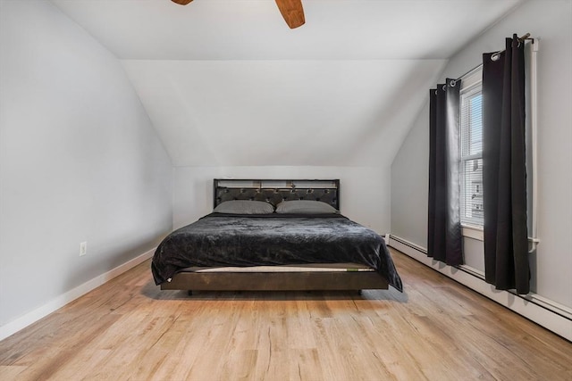 bedroom with ceiling fan, vaulted ceiling, baseboard heating, and light hardwood / wood-style flooring