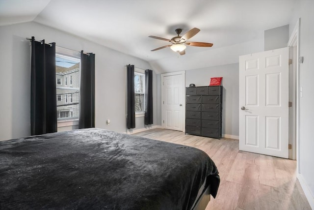 bedroom with light hardwood / wood-style floors, ceiling fan, and lofted ceiling