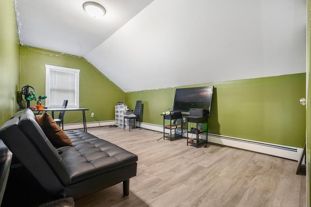 interior space featuring light hardwood / wood-style floors, vaulted ceiling, and a baseboard heating unit