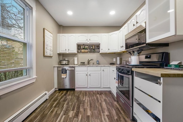 kitchen with sink, dark hardwood / wood-style floors, a baseboard radiator, white cabinetry, and stainless steel appliances