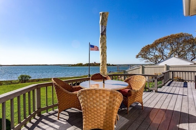 wooden terrace with a lawn and a water view