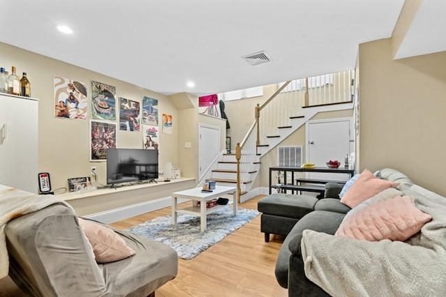 living room with wood finished floors, stairway, and recessed lighting