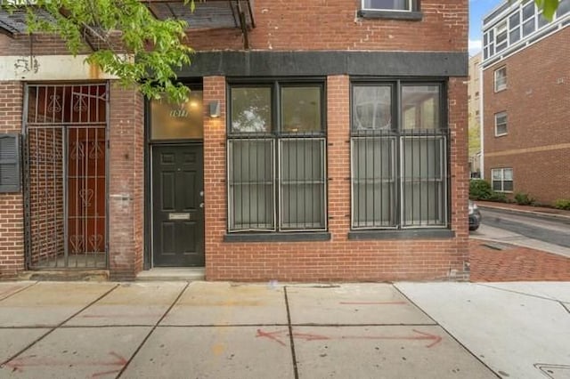 view of exterior entry featuring brick siding