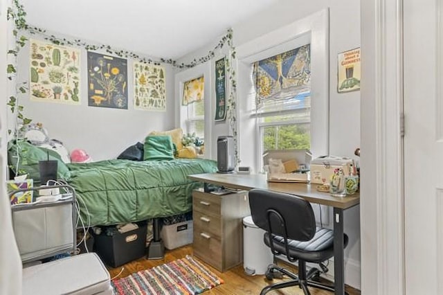 bedroom featuring light wood finished floors and a desk