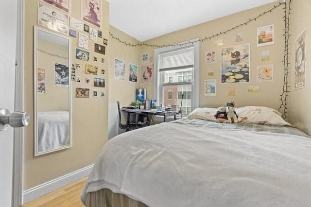bedroom with baseboards and wood finished floors