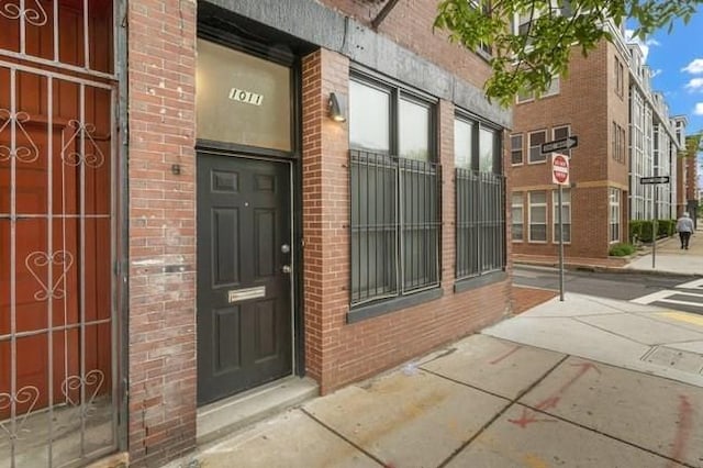 doorway to property with brick siding