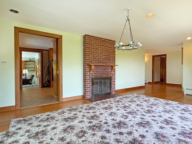 85 Warfield Rd, Charlemont, MA 01339 - unfurnished living room with wood finished floors, a chandelier, baseboards, and a fireplace