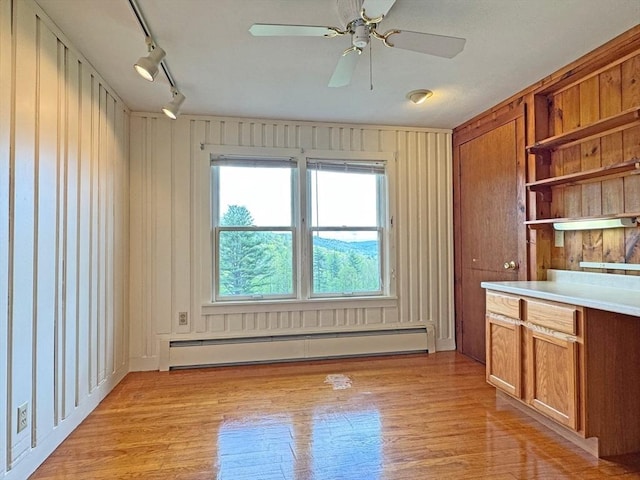 85 Warfield Rd, Charlemont, MA 01339 - unfurnished dining area with a baseboard radiator, light wood finished floors, ceiling fan, track lighting, and wood walls