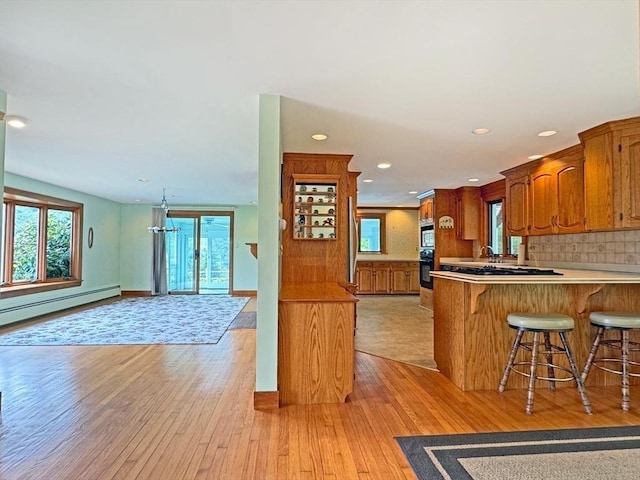 85 Warfield Rd, Charlemont, MA 01339 - kitchen featuring black oven, healthy amount of natural light, brown cabinetry, light wood-style floors, and recessed lighting