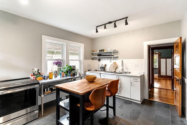 57 Atherton St Unit 57, Somerville, MA 02143 - kitchen featuring stainless steel electric range oven, white cabinets, light countertops, backsplash, and track lighting