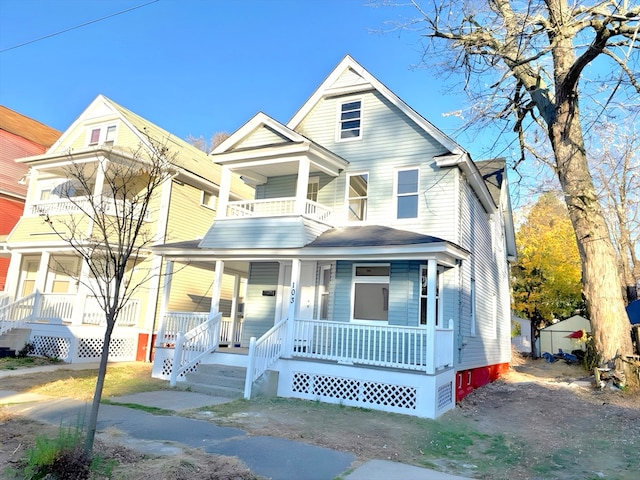 view of front facade featuring a balcony, covered porch, and a storage unit