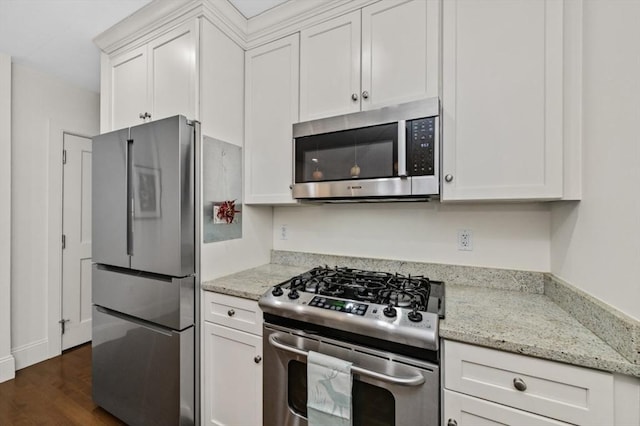 116 Rantoul St Unit 503, Beverly, MA 01915 - kitchen featuring appliances with stainless steel finishes, white cabinetry, dark wood finished floors, and light stone counters