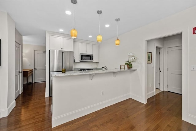 116 Rantoul St Unit 503, Beverly, MA 01915 - kitchen featuring stainless steel appliances, a peninsula, dark wood-style floors, white cabinetry, and recessed lighting