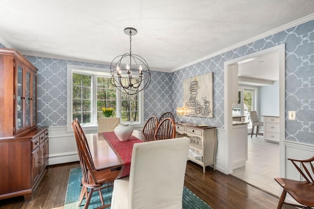 dining room with dark wood finished floors, crown molding, wainscoting, a notable chandelier, and wallpapered walls