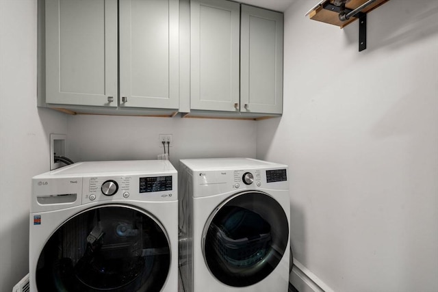 clothes washing area with washing machine and dryer and cabinet space