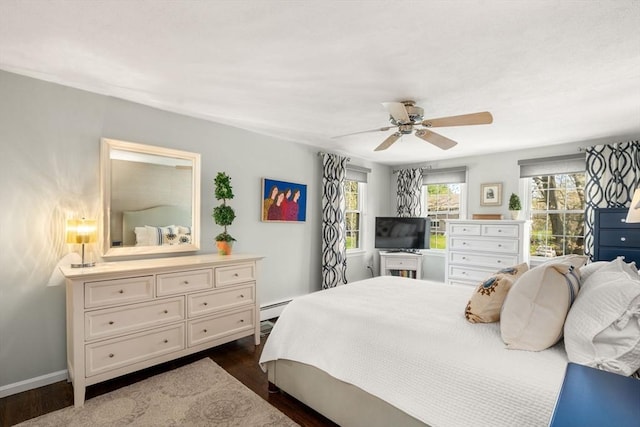 bedroom featuring dark wood-type flooring, baseboards, baseboard heating, and ceiling fan