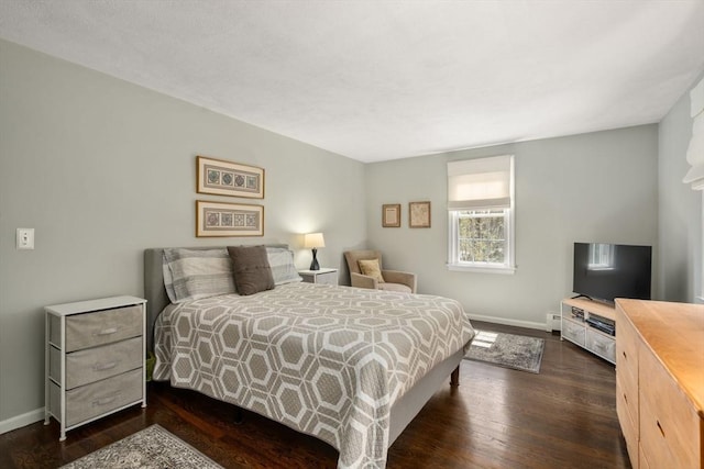 bedroom featuring baseboards and dark wood-type flooring
