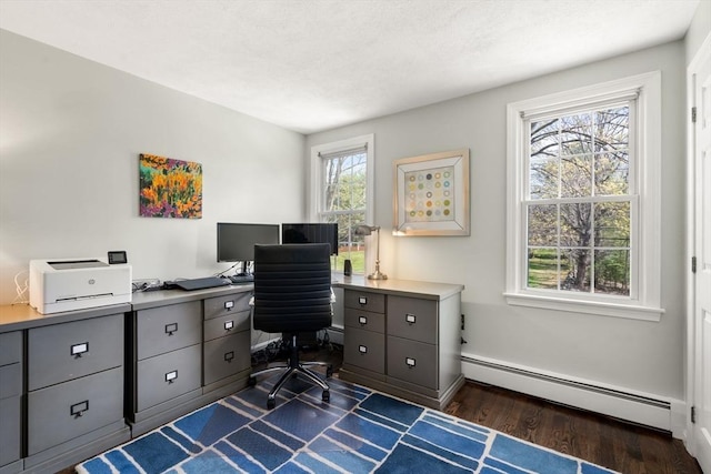 office space featuring a baseboard heating unit, baseboards, and dark wood-type flooring