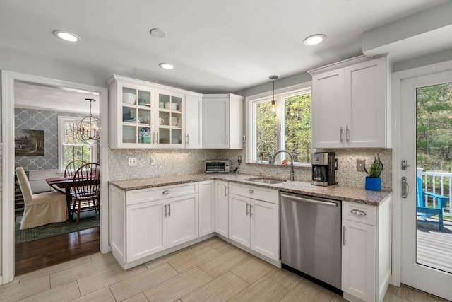 kitchen with a sink, white cabinets, a healthy amount of sunlight, and dishwasher