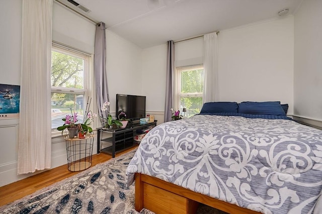 bedroom featuring wood finished floors and ornamental molding