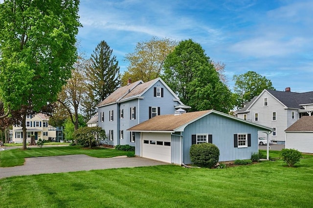 traditional home featuring a front yard, asphalt driveway, board and batten siding, and a garage