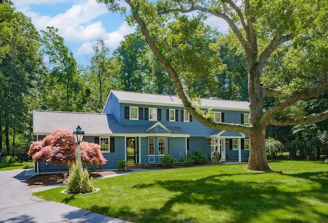 view of front of house featuring aphalt driveway and a front lawn