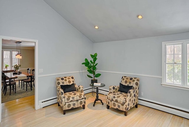 sitting room with a baseboard heating unit, lofted ceiling, and hardwood / wood-style floors