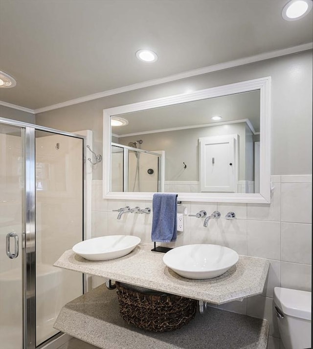 full bath featuring toilet, a shower stall, ornamental molding, and a sink