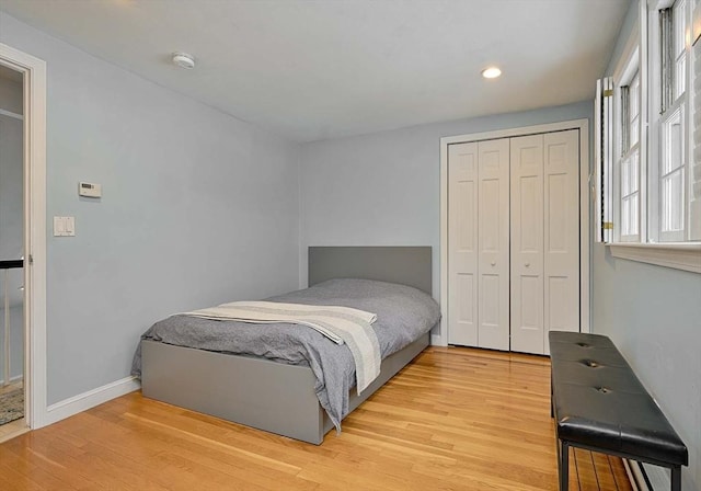 bedroom featuring a closet, recessed lighting, light wood-style flooring, and baseboards