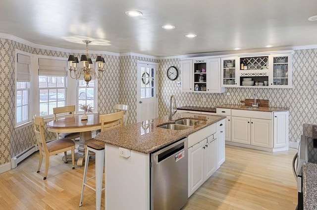 kitchen with a sink, wallpapered walls, light wood finished floors, and dishwasher