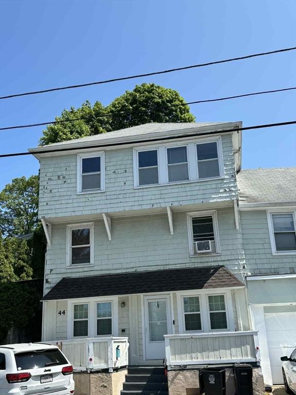 44 Cherry St Unit 2, Swampscott, MA 01907 - view of front facade featuring covered porch, a garage, cooling unit, and a shingled roof