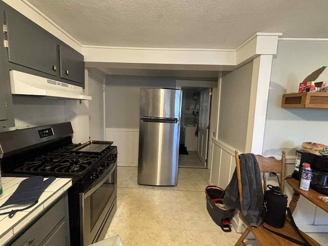 44 Cherry St Unit 2, Swampscott, MA 01907 - kitchen with stainless steel appliances, under cabinet range hood, a wainscoted wall, a textured ceiling, and light flooring