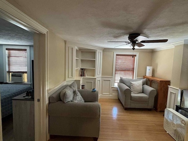 44 Cherry St Unit 2, Swampscott, MA 01907 - living room featuring a textured ceiling, light wood-type flooring, ceiling fan, built in features, and crown molding