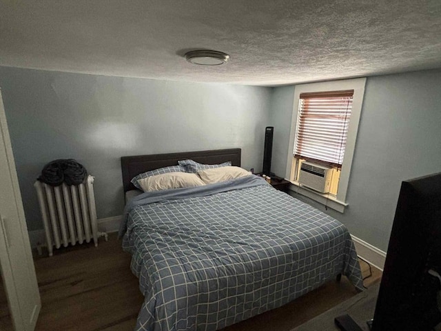 44 Cherry St Unit 2, Swampscott, MA 01907 - bedroom featuring radiator heating unit, a textured ceiling, baseboards, wood finished floors, and cooling unit