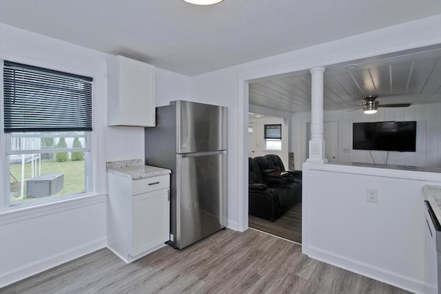 kitchen with freestanding refrigerator, light wood-style floors, white cabinetry, and open floor plan