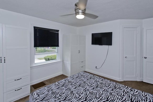 bedroom with dark carpet, baseboards, and a ceiling fan