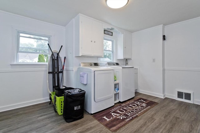 laundry area featuring cabinet space, separate washer and dryer, wood finished floors, and baseboards